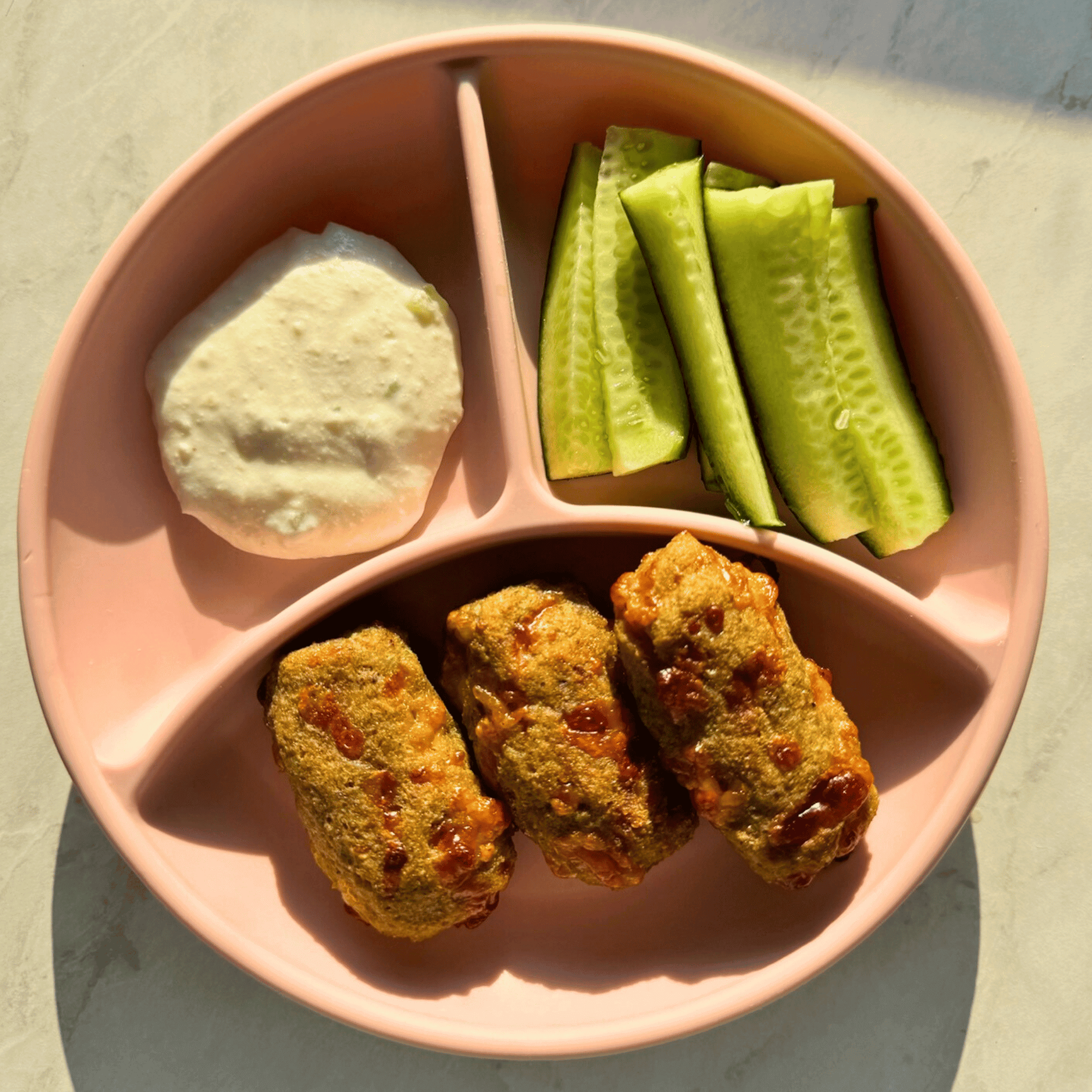 Cheesy broccoli fingers served with hummus and cucumber sticks for babies and toddlers